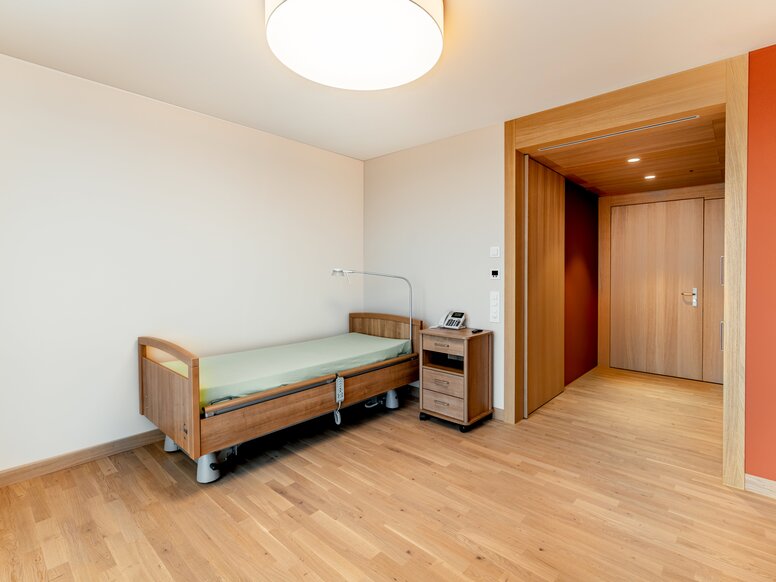 Pflegebett mit Nachttisch im Schlafzimmer